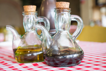 two bottles of balsamic vinegar and olive oil on a table