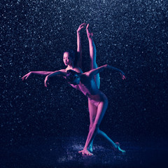Two young female ballet dancers under water drops