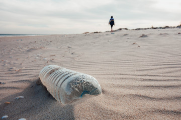 Plastic bottle on the beach sand. Plastic pollution of the oceans concept.