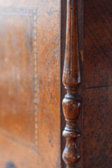 Texture of an old tree of red color with time traces in the form of scrapes, scratches, spots. The vintage ornament and carved details were repeatedly restored. Ready photo background.