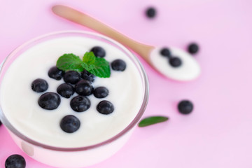 Close up yogurt with fresh blueberries  fruit in glass bowl  on pink background