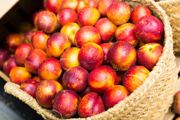 ripe nectarines in wicker baskets on counter