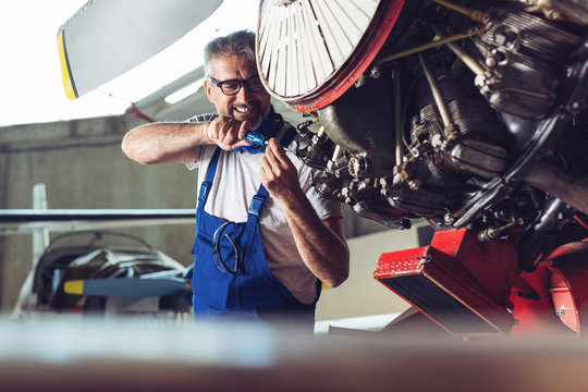 Senior engineer repairing aircraft engine 