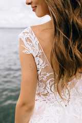 bride's back in lace dress with a bouquet