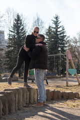 Daughter with father on a walk in a city park on a spring day, concept of family, parents generation