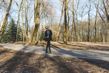 Obraz premium generation girl z walks through a city park on a spring afternoon, sunny spring background