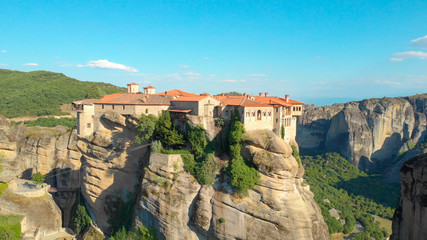 AERIAL: High stone formations surround the idyllic secluded village in Greece.