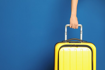 Woman with stylish suitcase against color background, closeup. Space for text