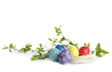 Painted Easter eggs and blossoming branches on white background