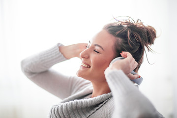 Fototapeta premium Woman with headphones over her head listen music and smile