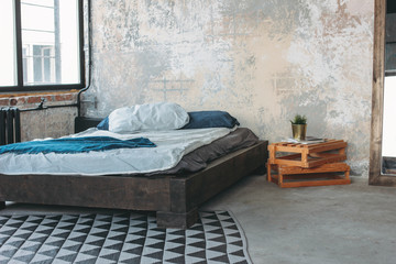 Modern eco loft interior in bedroom, concrete floor, bed, minimalism