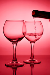 Wine glass with a bottle of wine on a red gradient background