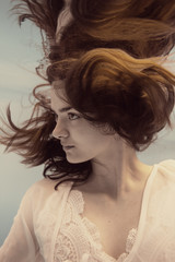 Portrait of a girl in a white dress under water