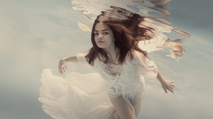Portrait of a girl in a white dress under water