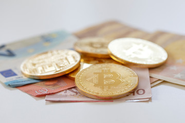 Bitcoins on first plan as virtual banknotes with real money on the desk