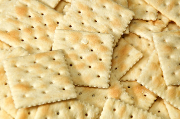 Close up of saltine crackers filling entire image, also known as soda and soup crackers.