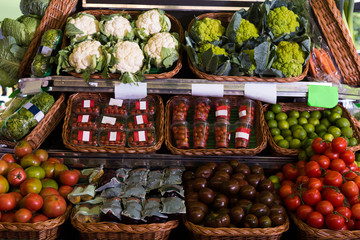 vegetables and fruits in wicker baskets on counter of greengrocery