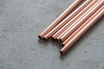 Close-up many new copper dyne pipes on the concrete floor. Concept installation, replacement of plumbing, repair of the pipeline, professional master plumber, leakage pipe