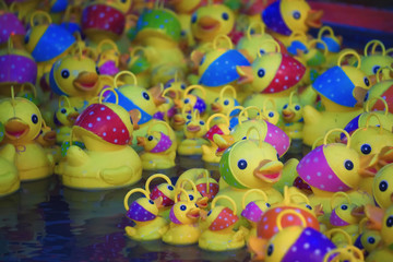 Fototapeta na wymiar Plastic yellow ducks in a fair, France.
