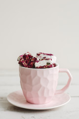 Pink coffee cup with sweet Turkish Delight with edible flower petals. Nougat