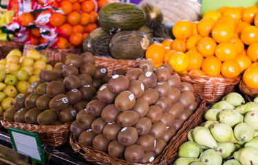 ripe kiwi in wicker baskets on counter market