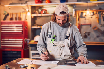 Male carpenter fixing old wood in a retro vintage workshop.