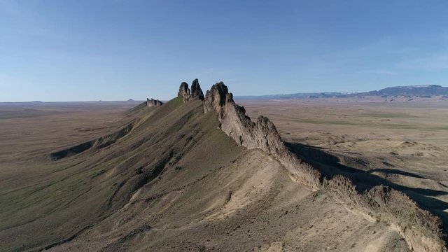 Aerial moving along tall desert rock formation
