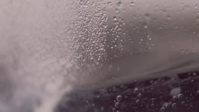 Slow motion close up of a chemical reaction creating fizzy bubbles
