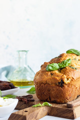 Savoury loaf cake with dried tomatoes, mozzarella and basil. Selective focus.
