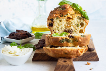 Savoury loaf cake with dried tomatoes, mozzarella and basil. Selective focus.