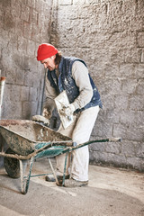 Real construction worker making a wall inside the new house.