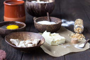 Ingredients for making sweet yeast bread or buns - flour, egg, milk or buttermilk, butter, sugar, lemon or orange zest, yeast. Food background. Copy space.