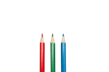 Lápices de colores rojo, verde y azul lápices para dibujar y pintar sobre un fondo blanco liso y aislado. Vista de frente o superior. Copy space