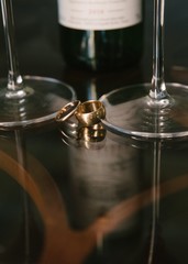 Gold wedding rings lie on a glass table close-up