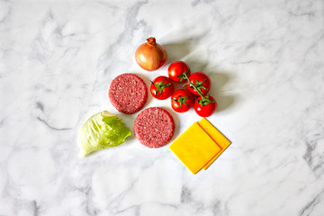 Hamburger iingredientes such as cheddar cheese, beef, onion, tomatoes, lettuce