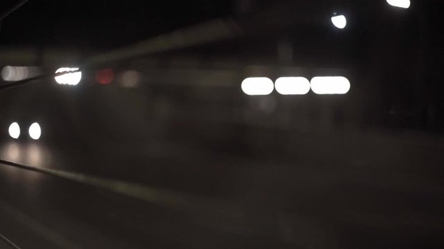 Timelapse of cars passing under a bridge and out of focus. Shot through railing of sidewalk.