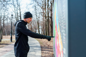 Image of sports man at map in park.