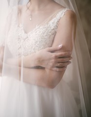 Young woman posing in a white wedding dress close up