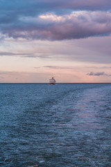 Ship following in the horizon with the sun going down, Finland