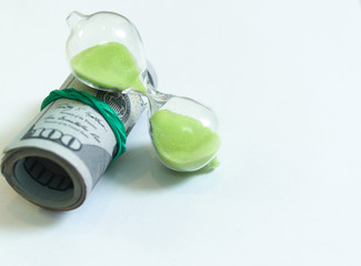 One hundred dollar bills Roll and hourglass. on a white background. concept - time is money