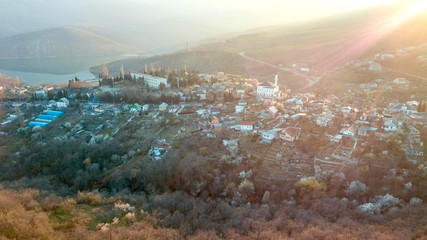 Mosque in the middle of the village illuminated by a ray of sunshine. View from above.