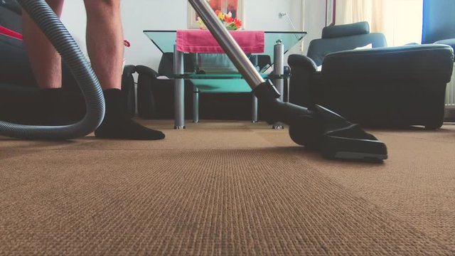 Man cleaning with the vacuum cleaner