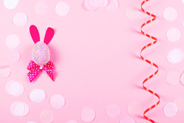 Easter bunny and serpentine on pink background.