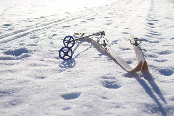 old wooden cross country skis and an empty snowy ski track