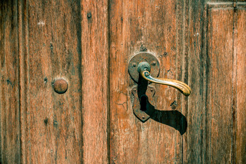 Vintage doorknob on an old weathered door &ndash; Rustic entrance background