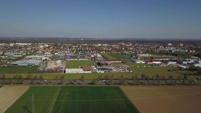 Aerial drone footage of Haunstetten, a suburb of Augsburg in Germany. View over the federal Highway B17 towards the commercial and industrial district of Haunstetten.