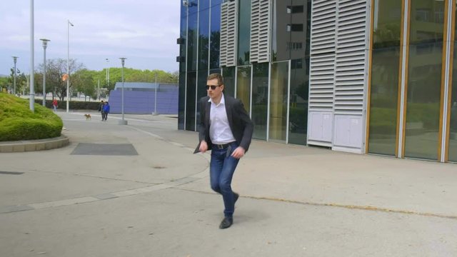 Young man in a suit running in a hurry . 4 K