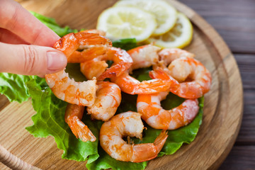 female fingers take fried shrimp in the background of the plate with them