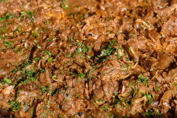 Close up of a large portion of cooked cut cabbage with green dill leaves in display at a street food market