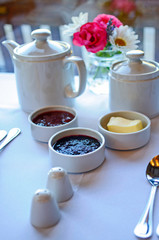 cup of tea with teapot and flowers on wooden table
